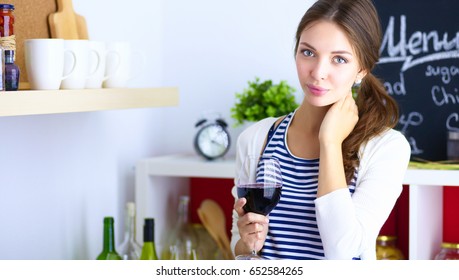 Pretty Woman Drinking Some Wine At Home In Kitchen