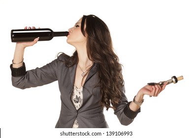 pretty woman drinking wine from the bottle and holding wine opener in the other hand