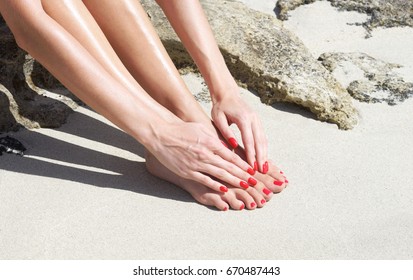 Pretty Woman Feet With Red Manicure And Pedicure: Relaxing On Sand. Holiday, Vacation, Spa, Summer: Concept.