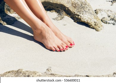 Pretty Woman Feet With Red Pedicure: Relaxing On Sand. Holiday, Vacation, Spa, Summer: Concept.