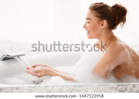 Pretty Woman Filling Bath With Water, Checking Temperature, Copy Space