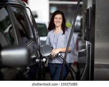 Pretty Woman Filling Her Car With Petrol At Gas Statiion