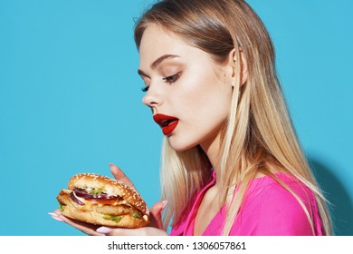Pretty woman with hamburger on blue background Fastfood - Shutterstock ID 1306057861