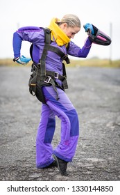 Pretty Woman Happy, Dressed In Jumpsuit And Parachute Harness On Airport Runway Ready For Skydive Jump