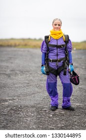 Pretty Woman Happy, Dressed In Jumpsuit And Parachute Harness On Airport Runway Ready For Skydive Jump