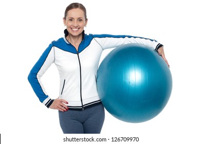 Pretty Woman Holding Big Blue Pilate Ball Against Her Waist And Smiling.