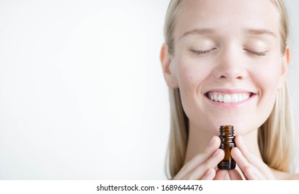 A Pretty Woman Holding A Bottle Of Essential Oils, Breathing The Aroma. Natural Alternative Medicine.