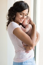 Pretty Woman Holding A Newborn Baby In Her Arms