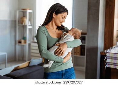 Pretty woman holding a newborn baby in her arms. Single mother parent concept. - Powered by Shutterstock