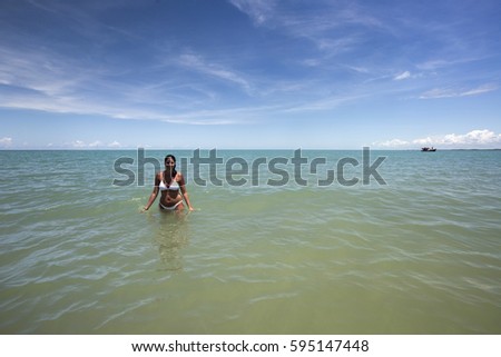 Pretty woman into brazilian beach on a sunny day in Corumbau, Bahia, Brazil. february, 2017.