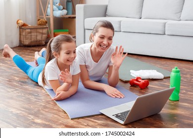 Pretty Woman Junior Small Little Girl Lady, Mother And Daughter Lay On Yoga Mat At Home Room, Have Conversation On Laptop Computer Online. Skype Call With Family, Happy Faces, Say Hi! Natural Concept!