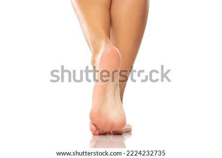 Pretty woman legs and sole feet on white studio background