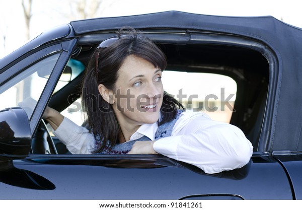 Pretty\
woman looking behind her as she backs up her\
car