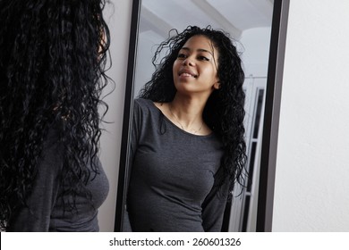 pretty woman looking at herself at mirror