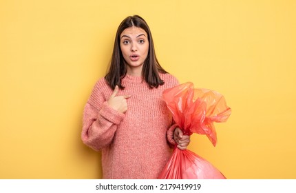 Pretty Woman Looking Shocked And Surprised With Mouth Wide Open, Pointing To Self. Trash Bag Concept