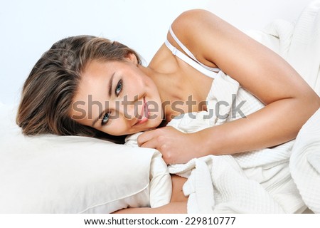 Pretty woman lying down on her bed at home waking up in the morning