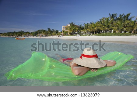 Pretty woman lying in shallow water by a tropical beach