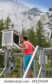 Pretty Woman Meteorologist Reading Meteodata Instruments In Modern Meteorologic Observation Station, High In Mountains