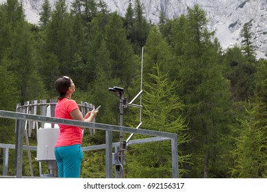 Pretty Woman Meteorologist Reading Meteodata Instruments In Modern Meteorologic Observation Station, High In Mountains