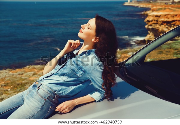 pretty woman near\
the car a rest near the\
sea