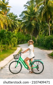 Pretty Woman With Old Vintage Bicycle On A Background Of Palm Trees. Young Girl Riding Bike In Seychelles Or Thailand Tropical Jungle With Coconut Palms. Summer Holiday Tourist Activity.