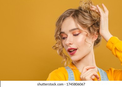 Pretty Woman With Orange Eye Shadow Makeup On Yellow Background