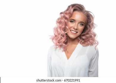 Pretty Woman With Pastel Pink Hair. Beauty Fashion Smiling Model Girl With Long Curly Hair And Colourful Make-up. White Backdrop