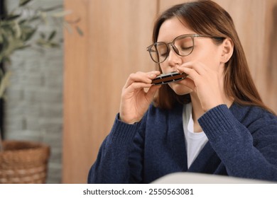 Pretty woman playing harmonica at home - Powered by Shutterstock