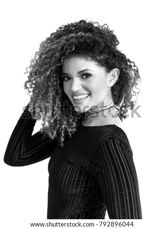 Pretty woman portrait with gorgeous curly hair looking and smiling, monochrome