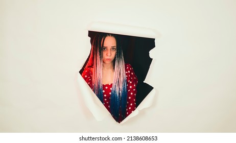 Pretty Woman Posing In Hole Of White Background In Studio. Young Shy Female Looking At Camera And Smiling