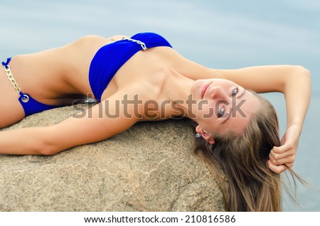 Pretty woman posing near the sea.