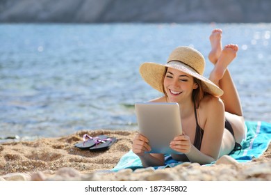 Pretty woman reading a tablet reader on the beach on vacations with the sea in the background                - Powered by Shutterstock