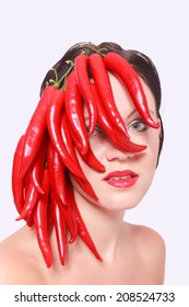 Pretty Woman With Red Hot Spicy Cayenne Chili Peppers Covering Her Face. / Pretty Woman With Red Hot Chili Peppers On Face