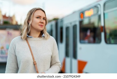 Pretty Woman Stands At A Tram Stop.