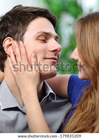 pretty woman stroking the cheek of her boyfriend with love
