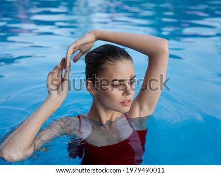 pretty woman in swimsuit holds hands above head luxury leisure