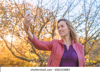 Pretty Woman Taking Selfie Photo On Mobile Phone In Autumn Park, South Australia