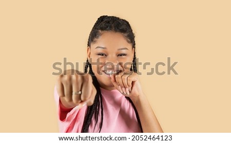 pretty woman throws a fist, beige background
