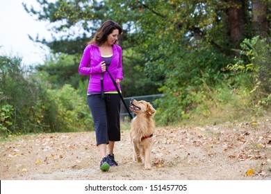 A Pretty Woman Walking Her Dog On A Trail