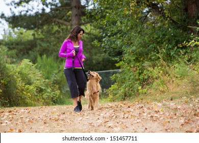 A pretty woman walking her dog