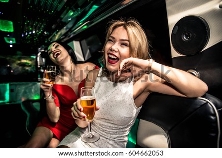 Pretty women having party in a limousine car