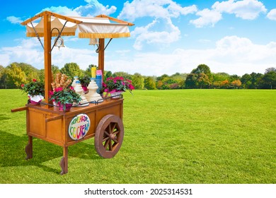 Pretty Wooden Portable Traditional Italian Picturesque Ice Cream Cart With Umbrella In A Public Park