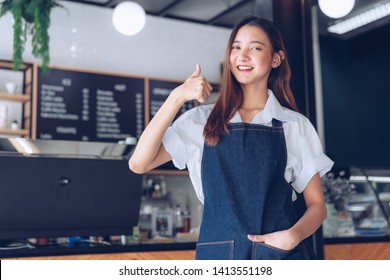 Pretty young asian waitress standing arms crossed in cafeteria.Coffee Business owner Concept.  barista in apron smiling at camera in coffee shop counter - Shutterstock ID 1413551198