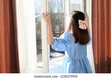 Pretty Young Asian Woman Opening Window In Room