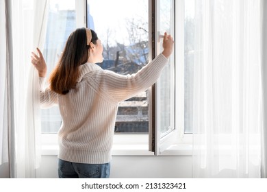 Pretty Young Asian Woman Opening Window At Home