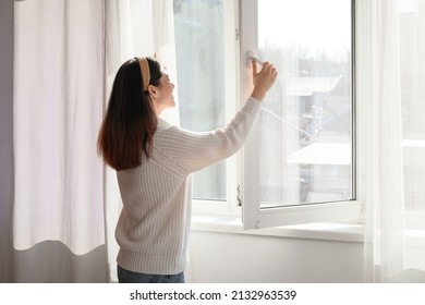 Pretty Young Asian Woman Opening Window At Home