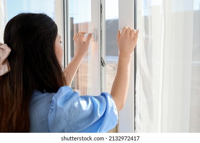 Pretty Young Asian Woman Opening Window In Room