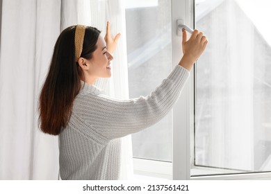 Pretty Young Asian Woman Opening Window At Home