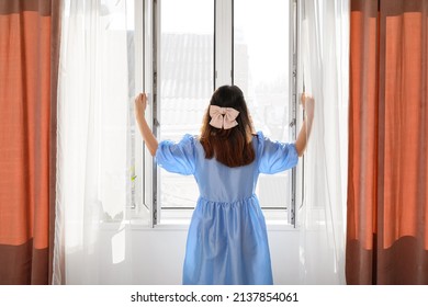 Pretty Young Asian Woman Opening Window In Room