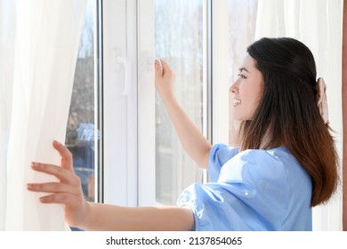 Pretty Young Asian Woman Opening Window In Room